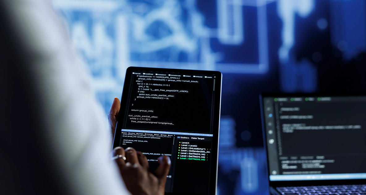 Engineer reviewing code on a tablet in a technology workspace